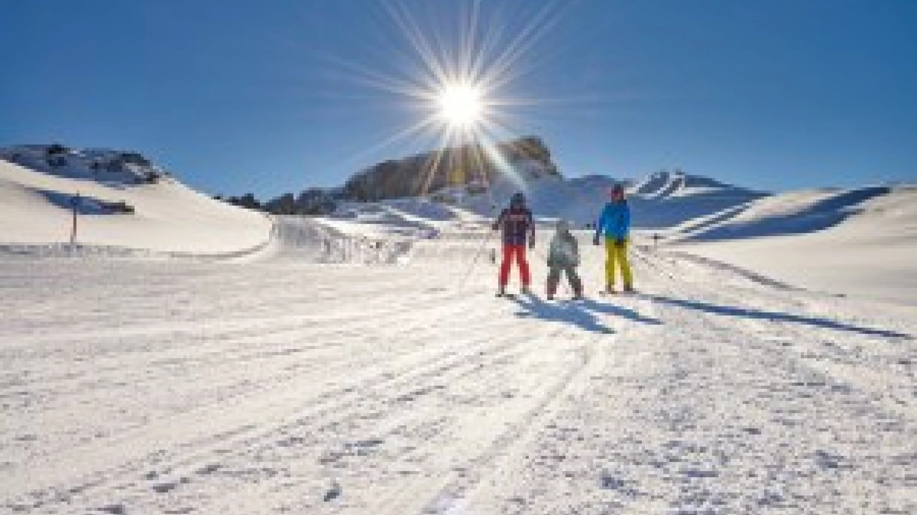 Sonne über Familie im Schnee