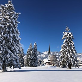 Gastgeber im Oberallgäu: Blick von Fischen-Au auf das verschneite Fischen - Alpin Hotel bichl 761 