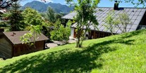 Hotels und Ferienwohnungen im Oberallgäu - Parken & Anreise: Fahrrad-Unterstellraum - Alpenhaus Oberstdorf - Garten (Sommer) - ALPENHAUS Oberstdorf